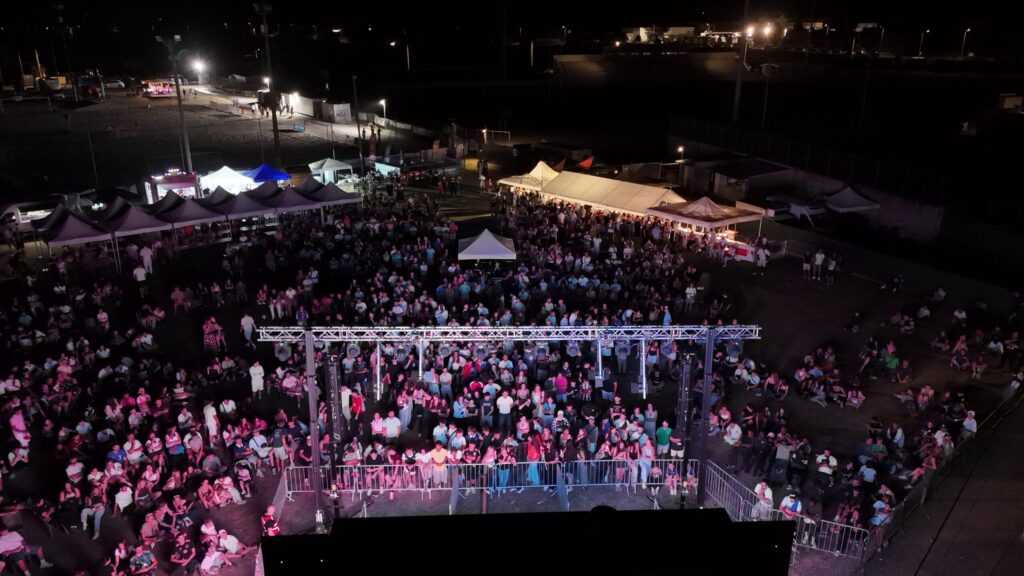 Vue au drone d'une foule dans une fan zone regardant un match sur un écran géant LED extérieur